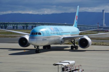 Izumisano, France - Oct. 25, 2025 - Boeing 787 Dreamliner aircraft from the airline company Korean Air, taxiing at Osaka International Airport (KIX); afar is the Sky Gate Bridge R to the mainland
