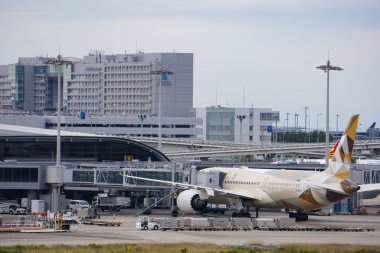 Izumisano, Japonya - 25 Ekim 2025 - Osaka Uluslararası Havalimanı Terminal 2 'de Emirati havayolu Etihad' dan Boeing 787 Dreamliner uçağı; arkasında Aeroplaza 'daki Nikko Kansai Havalimanı bulunmaktadır.