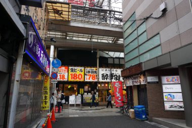 Osaka, Japonya - 26 Ekim 2025 - Doyamacho 'da bir sokak köşesi, Umeda İstasyonu' na yakın, renkli reklam ve ticari panoların altında küçük yerel işletmeleri olan canlı bir alışveriş alanı.