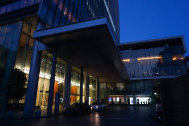 Guangzhou, Çin - 10 Kasım 2025 - Zhujiang Xin Cheng Merkezi İş Bölgesi 'ndeki Huacheng Meydanı' nda gece sahnesi: R ve F Merkezi 'nin güney tarafındaki cam cephe ve beton sütunlar