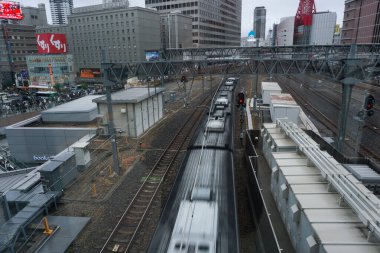 Osaka, Japonya - 26 Ekim 2025 - Osaka İstasyonu 'ndan geçen tren, Kita-ku Koğuşundaki Umeda' nın merkez bölgesinde; kırmızı Hep Beş Dönme Çarkı rayların yanında görünür durumda.