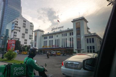 Phnom Penh, Kamboçya - 8 Kasım 2025 - Fransız Protektorası tarafından 1932 'de inşa edilen eski tren istasyonundaki cep telefonu ofisleri, RHB banka şubesi, FTB Kulesi; scooter ve Rolls-Royce Wraith sürücüleri yan yana kullanılıyor.