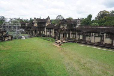 Angkor, Kamboçya - 6 Kasım 2025 - Siem Reap Eyaleti 'ndeki UNESCO Dünya Mirası Alanı Angkor Vat' ın 12. yüzyıl merkez tapınağını çevreleyen Ortaçağ galerisi, solda iskele ve restorasyon çalışmaları