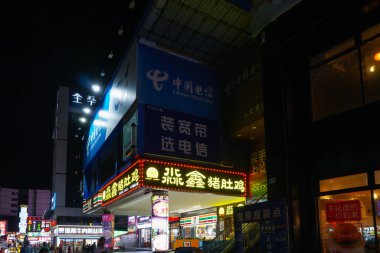 Guangzhou (Canton), Çin - 10 Kasım 2025 - Helongqi Yolu 'nun yanındaki Renhe Mahallesi' nde bir ticaret merkezi, Çin Telekom için Seven Eleven mağazası, restoranlar ve aydınlatılmış reklam panoları