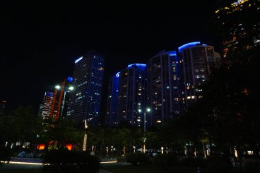 Guangzhou (Kanton), Çin - 10 Kasım 2025 - Zhujiang Xin Cheng Merkez İş Bölgesi 'ndeki Linjiang Bulvarı boyunca aydınlık pencereli apartmanlar ve ofis kuleleri (