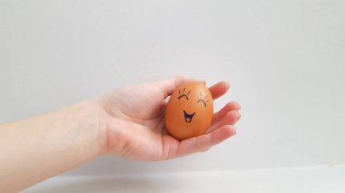 Paskalya yumurtaları elinde neşeli bir yüz şeklinde süslenir.