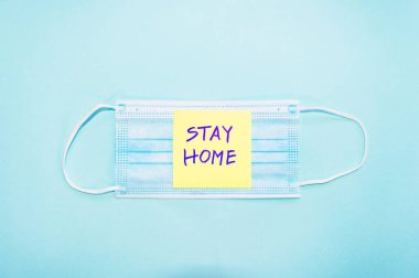 Mavi arka planda yüz maskesi ve ortada 