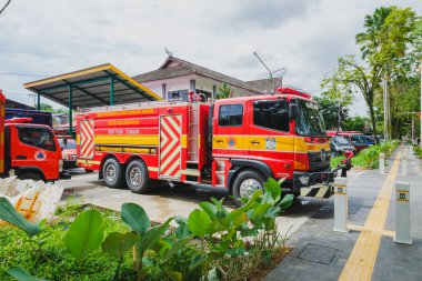Balikpapan, Endonezya - 21 Kasım 2025. Doğu Balikpapan bölgesindeki Badan Penanggulangan Bencana Daerah (BPBD) istasyonunda park edilmiş kırmızı ve sarı Hino itfaiye aracının profesyonel bir gün çekimi. Araç Endonezya 'dan resmi olarak beni içeriyor