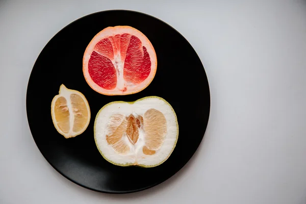 Fruit on black plate — Stock Photo, Image