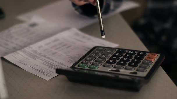 Pendekatan seorang pria menggunakan kalkulator. Bekerja dari rumah. Perhitungan angka besar — Stok Video