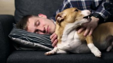 Evde köpekle oynayan bir genç..