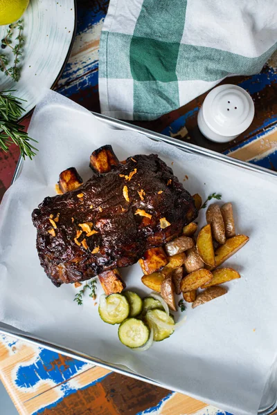 Patatesli pirzola ve salatalık turşusu.