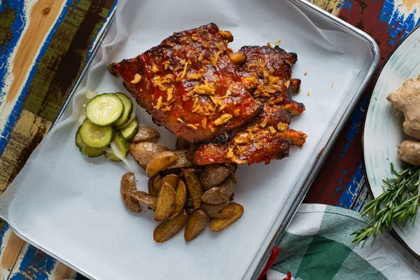 Beyaz tabakta patatesle kızartılmış kaburgalar.