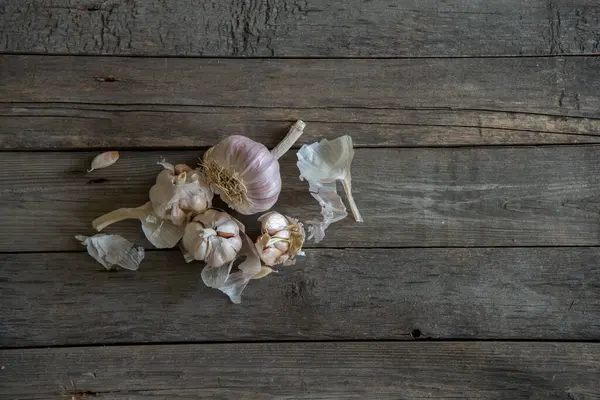 Sarımsak baş ve karanfilleri gri renkli ahşap bir arka planda.