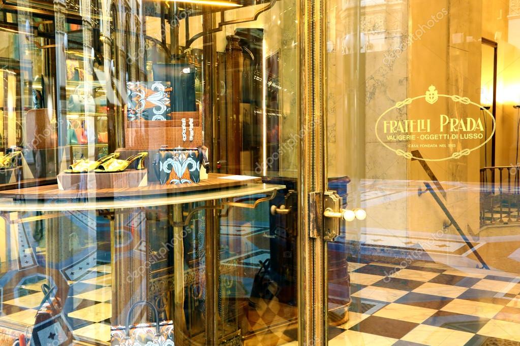 Milan, Italy. Detail of the entrance and a window of the Fratelli Prada boutique in Galleria Vittorio Emanuele. At right the glass door of the boutique with the logo. At left detail of a window.