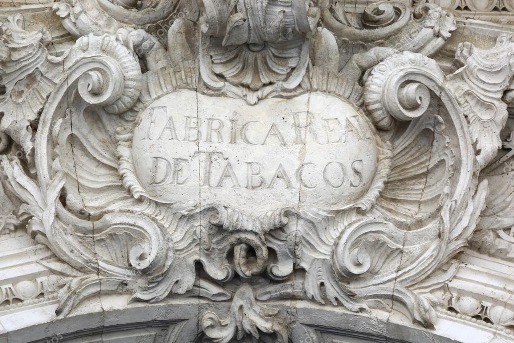 Old sign Fabrica Real de tabacos on stone molding in Sevilla