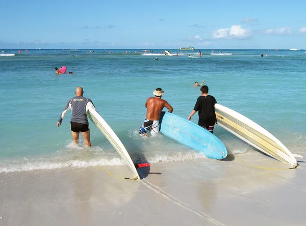 Trzech surferów wejść w wodzie — Zdjęcie stockowe