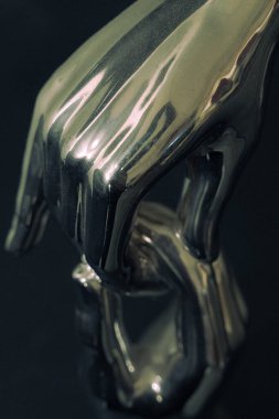 Bir elin diğerinin elini kaldırmasına yardım ettiği bir heykel..