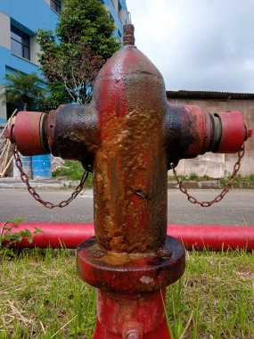 Kırmızı yangın musluğu sızdırıyordu ve paslanmaya başlamıştı. çift yönlü yangın musluğu sütunu.