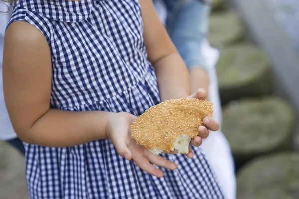 Girl holding piece of bread — Stock Photo, Image