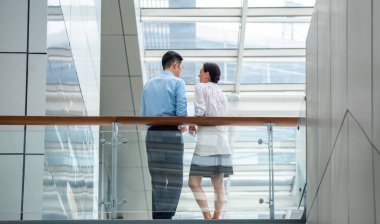 İş arkadaşlarının koridorda tartıştıkları arka görüş. İki başarılı iş adamının arka planı projeyi tartışıyor veya planlıyor