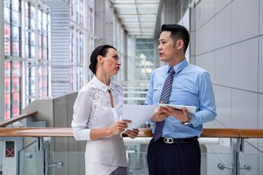 Profesyonel çalışanlardan oluşan bir ekip yeni proje hakkında fikir alışverişinde bulunuyor. İş adamları ofis lobisinde tartışıyorlar.