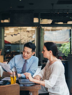 İş ortakları restoranda başarılı bir toplantı yapıyorlar. Kendine güvenen iki iş adamından oluşan bir ekip kağıtlara bakıyor. İş adamı iş kadınına belgeleri gösteriyor