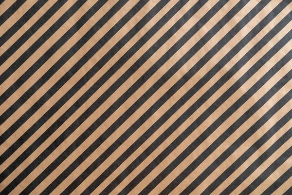 Black pattern stripe on brown paper background. Diagonal landscape black pattern stripe on recycled paper texture