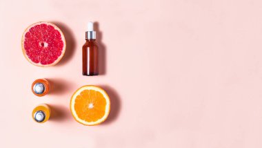 Yaşlanma önleyici cilt bakımı ürünleri ve çok renkli arka planda fotokopi alanı olan araçlar. Yeşim silindir, pipet, yüz serumu, yüz ampulü ve açık pembe ve parlak pembe arka planda açık pembe vitaminler.