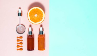 Yaşlanma önleyici cilt bakımı ürünleri ve çok renkli arka planda fotokopi alanı olan araçlar. Yeşim silindir, pipet, yüz serumu, yüz ampulü ve açık pembe ve parlak pembe arka planda açık pembe vitaminler.