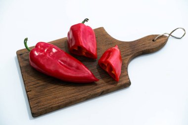 Tahta kesme tahtasındaki iki kırmızı biber beyaz arka planda izole edildi