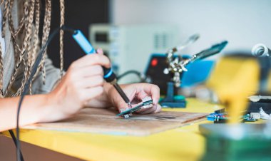 Kadın teknisyen elleri devre kartını inceliyor. Kapatın.