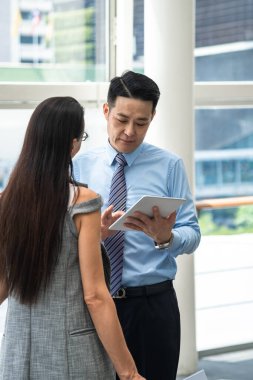 İş ortakları dijital tablet ve takım çalışması kavramını kullanarak yeni proje fikirlerini tartışıyor