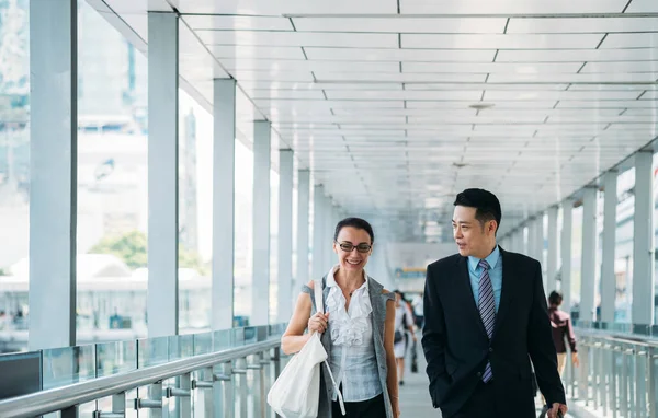 Businessman and businesswoman walking and talking . Smiling business people walking together