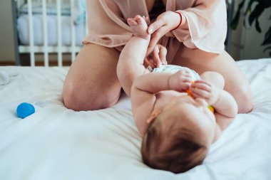 Çıngıraklı Tatlı Çocuk, yatak odasında bezini değiştiriyor. Annenin bebek bezini fotokopi aletiyle değiştirirken çekilmiş fotoğrafı..