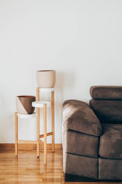 Ev Güzeli 'ndeki Çiçek standında iki Modern saksı Oturma odasında el yapımı boş kil tenceresi.