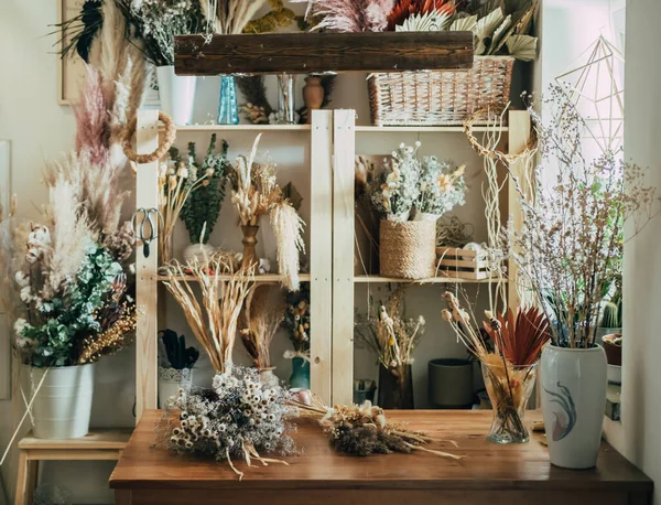 乾燥植物や花でいっぱいのテーブルと棚を備えた美しい小規模ビジネスワークショップ — ストック写真