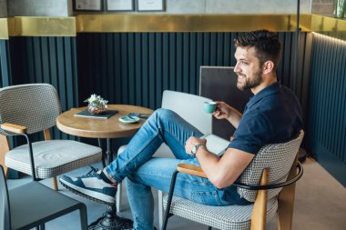 Kafede kahve içerken Dijital Tablet kullanan gülümseyen İşadamı. Mutlu iş adamı espresso içiyor ve restoranda otururken tablet tutuyor..