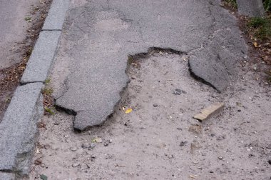 Eski gri asfalt yüzeyi terk edilmiş ve ihmal edilmiş..