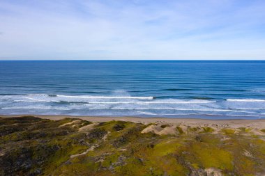 Pasifik Okyanusu 'ndan gelen dalgalar, Morro Körfezi, Kaliforniya' daki boş bir plaja ve kum tepelerine vurur. Kaliforniya 'nın bu kıyı bölgesi güzel doğal manzarasıyla bilinir..