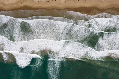 Pasifik Okyanusu 'ndan gelen dalgalar, Morro Körfezi, Kaliforniya' daki boş bir plaja ve kum tepelerine vurur. Kaliforniya 'nın bu kıyı bölgesi güzel doğal manzarasıyla bilinir..