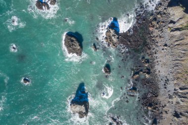 Pasifik Okyanusu, güzel bir kış gününde Kuzey Kaliforniya 'nın engebeli kıyı şeridine karşı kıyıya vurur. Manzaralı Pasifik Sahil Otoyolu Kaliforniya 'nın büyük bir kısmı boyunca uzanıyor..
