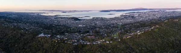 The first light of day illuminates San Francisco Bay and its surrounding cities. This famous body of water is bordered by San Francisco, Oakland, Berkeley, Sausalito, and Marin among other cities.