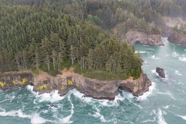 The Pacific Ocean washes against the scenic coast of southern Oregon. This rugged and rocky part of the Pacific Northwest is found along the Samuel H. Boardman State Scenic Corridor.