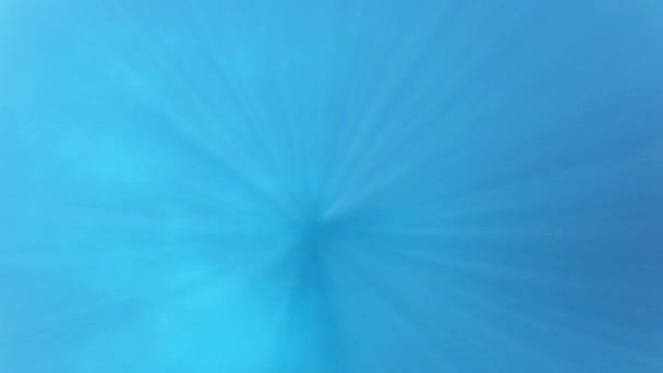 Balken van zonlicht doorboren het diepblauwe water — Stockvideo