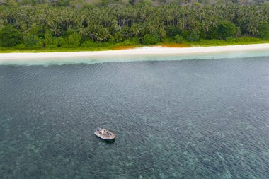 Endonezya 'nın Banda Denizi' ndeki uzak tropikal bir adanın deniz kıyılarında küçük bir tekne sürükleniyor. Bu bölge ve küçük adaları muhteşem deniz biyolojik çeşitliliğine ev sahipliği yapar..