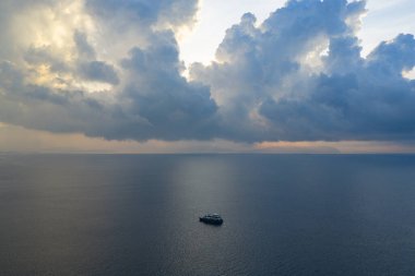 Güzel bir gündoğumu silueti Endonezya, Raja Ampat 'ta küçük bir dalış teknesini canlandırıyor. Bu bölge inanılmaz deniz biyolojik çeşitliliği nedeniyle Mercan Üçgeni 'nin kalbi olarak bilinir..