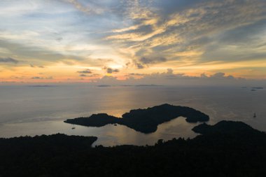 Endonezya 'nın Raja Ampat kentindeki Gam ve Yangeffo adalarını güzel bir günbatımı silueti kaplıyor. Bu bölge inanılmaz deniz biyolojik çeşitliliği nedeniyle Mercan Üçgeni 'nin kalbi olarak bilinir..