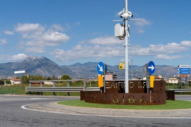 Sibari, Calabria, İtalya 'da bir kavşak. Arka planda Pollino dağ sırası görülebilir. Buna ek olarak, farklı noktalara işaret eden çeşitli yönlü yol işaretleri var..