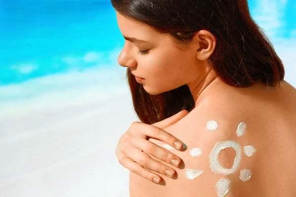 Retrato de mulher linda em biquíni com o sol desenhado em um ombro na praia — Fotografia de Stock